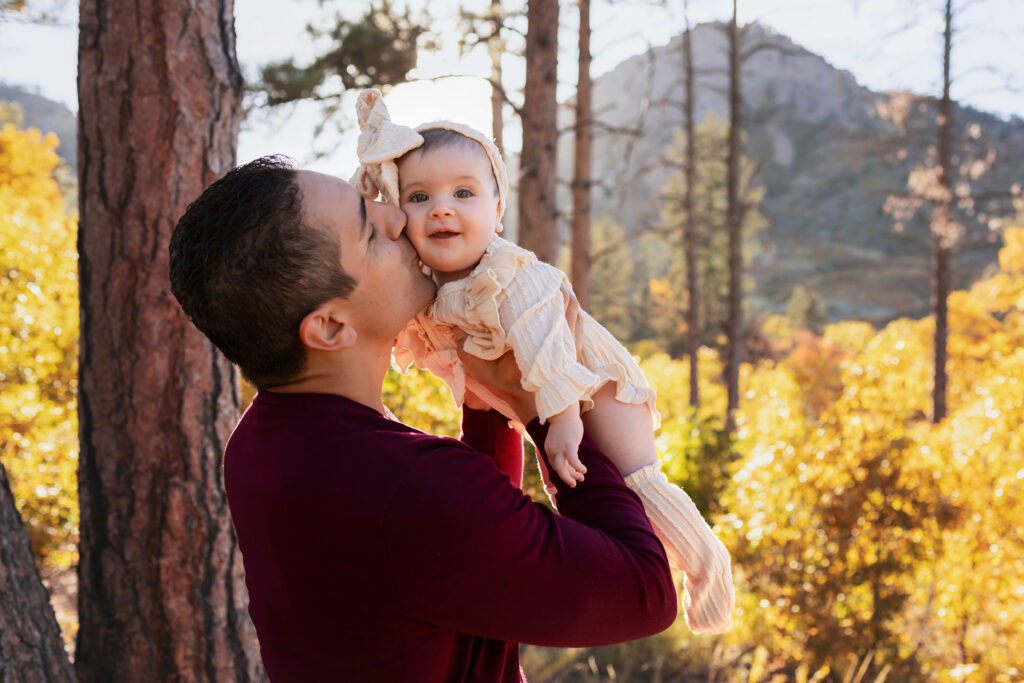 Dad kissing his baby on the cheek.