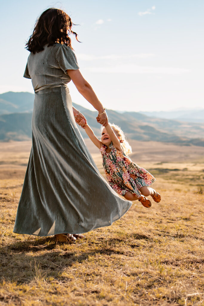 Mom twirling her daughter.