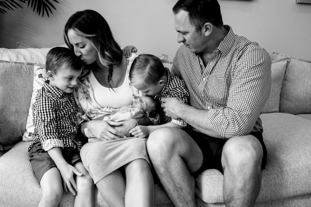 Family snuggling on couch with newborn