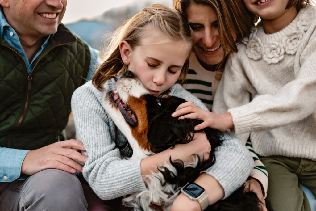 Little girl kissing her dog on the head.