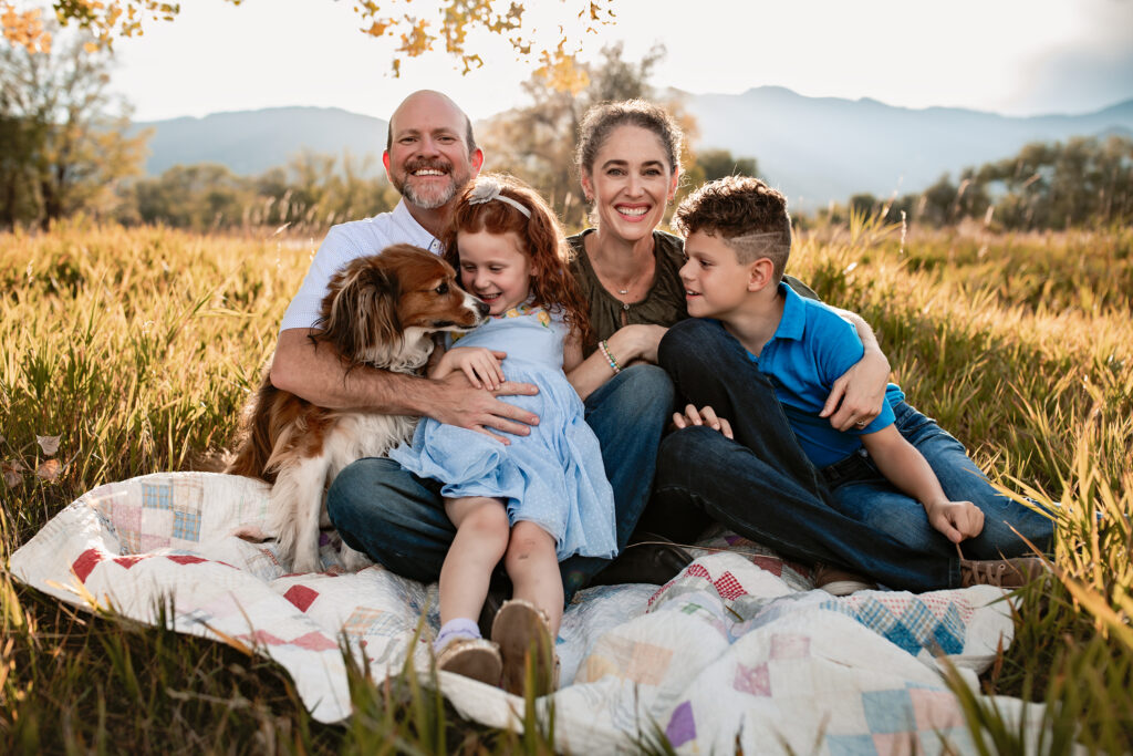 Family on a blanket with their dog.