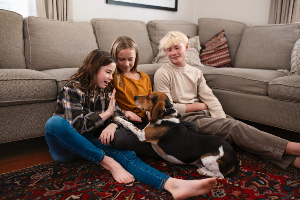 Kids with their pet dog in their home.