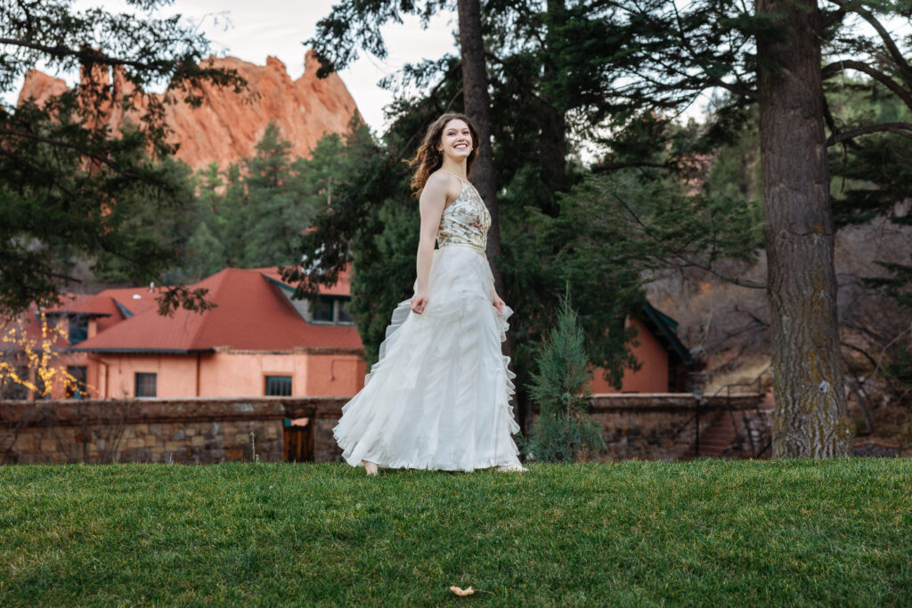 College senior walking in gown at Glen Eyrie Castle